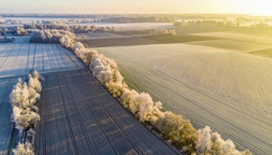 Bird Eye Perspective of Frost Covered Farmland. Seasonal Agricultural Scenery, winter and autumn