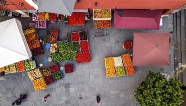 Traditional Mexican plaza with crates of peppers, onions, and tomatoes, economic prosperity in