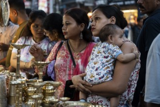 People shop for bronze and other metal items at a roadside stall on Dhanteras, in Guwahati, Assam,