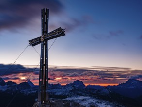 Sassongher summit cross at dawn, in the background Monte Cristallo, Monte Pelmo and Civatta,