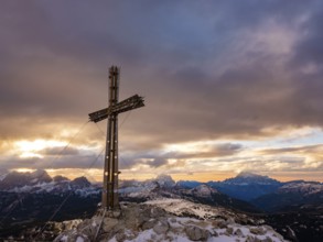 Sassongher summit cross at sunrise, in the background Monte Cristallo, Monte Pelmo and Civatta,