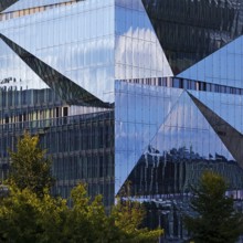Cube Berlin, cube-shaped office building with folded glass façade reflecting the surroundings,