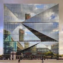 Cube Berlin, cube-shaped office building with inwardly folded glass façade reflecting the