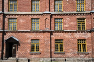 Brick façade with yellow windows, former paper factory and mill for the production of groundwood