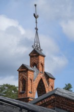 Iron ornamental element on roof peak, brick gable, former paper mill for the production of