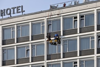 Two male glass cleaners abseiling down the hotel façade to clean windows, aletto Hotel Kudamm,