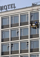 Two male glass cleaners abseiling down the hotel façade to clean windows, aletto Hotel Kudamm,
