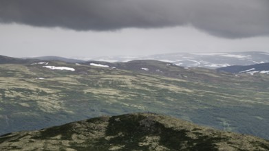 Vast mountain landscape with patches of snow and a cloudy atmosphere, pilgrimage route Olavsweg or