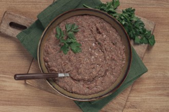 Red bean lobio, a traditional Georgian dish, on a wooden table, homemade