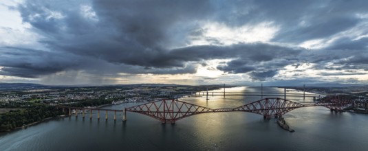 Sunset Panorama of Rain clouds over Forth Bridge from a drone, Queensferry Crossing, Forth Estuary,