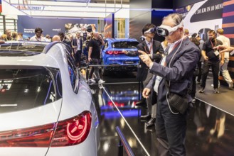 Mercedes trade fair stand with virtual presentation. Trade fair visitors with 3D glasses. The