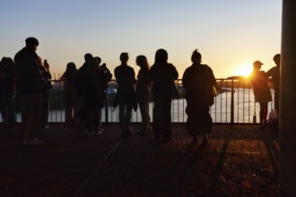 Crowd enjoying the view from the Elbphilharmonie over the Elbe at sunset, silhouettes, Plaza