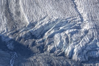 Intricate patterns of ice and rock are showcased in this stunning glacial landscape, revealing the