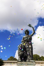Colourful balloons rise high above the statue of Bavaria into the white-blue sky, grand finale of