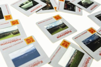 Many framed Kodachrome slides on a light table with magnifying glass, top shot