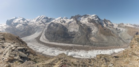 At dawn, the sun bathes the peaks of the Alps in a golden light and reveals stunning glaciers and