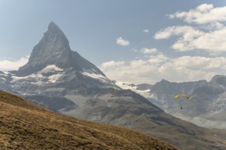 A person paraglides against the stunning backdrop of the Matterhorn mountain in Switzerland. The