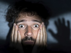 A close-up of a man whose face is marked by fear, symbolising anxiety disorders, panic attacks,