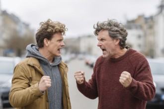 Two angry men arguing in the street, possibly triggered by a road traffic incident, symbolic image