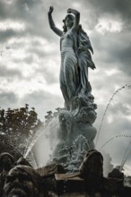 Undine Fountain with dramatic sky in the spa garden Baden, Lower Austria, Austria