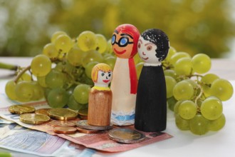 Wooden cone family with grapes and coins and banknotes, North Rhine-Westphalia, Germany