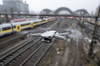 Ein Fernpilot steuert sein Quadrocopter, Drohne illegal über Bahnhofsgelände, Bahngelände,