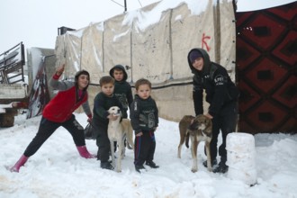 Displaced Syrian families and children living in refugee camps during harsh winter conditions,