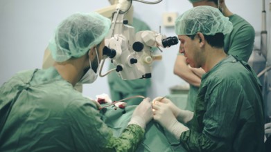 Several doctors performing a complex surgical operation inside an operating room for a displaced