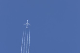 Airbus A340-300 jet aircraft of Lufthansa airlines in flight in a blue sky with vapour trails or