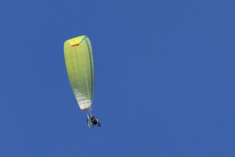 Paraglider flying in a blue sky, England, United Kingdom
