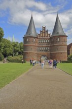 Historic Holsten Gate and pedestrians, tourists, Brick Gothic, brick building, city gate, landmark,
