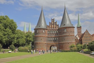 Historic Holsten Gate and pedestrians, tourists, St. Mary's Church, Lübeck St. Peter's Church