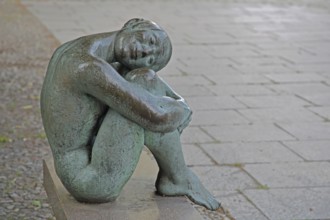 Sculpture Resting by August-Martin Hoffmann 1976, bronze sculpture, seated female figure on bench