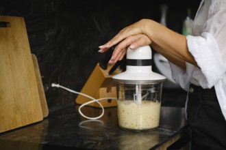 Close-up view of blending ripe bananas and sea buckthorn berries in a stylish kitchen. The focus is