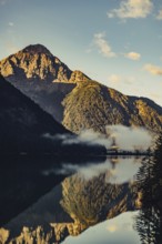 Sunrise with reflections and alpenglow in Lake Heiterwanger See in Tyrol in the Alps in Austria