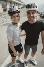 Woman and man riding racing bikes in Italy on Lake Garda