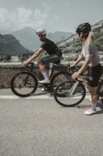 Woman and man cycling on Lake Garda in Italy. Sunny weather and dolce vita
