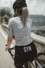 Young woman riding a racing bike on Lake Garda. Sunny weather and dolce vita