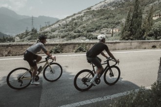 Woman and man cycling on Lake Garda in Italy. Sunny weather and dolce vita