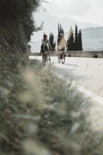 Woman and man riding racing bikes in Italy on Lake Garda