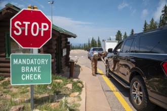 Colorado Springs, Colorado - A Pikes Peak ranger checks the temperature of brakes on a car