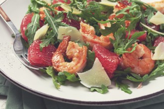 Fresh shrimp salad with arugula, grapefruit, and parmesan served in a bowl