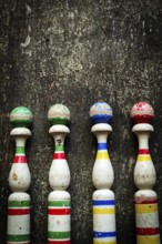 Vibrant wooden bowling pins stand aligned against a weathered surface, inviting players to enjoy a