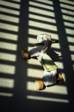 A vintage ride-on toy sits on a concrete surface, illuminated by sunlight streaming through a