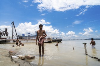 People bathe in the Brahmaputra River to seek relief from the intense summer heat in Guwahati,