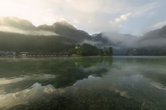 Mystical morning at Königssee in Schönau with boathouses and Christlieger. Sunrise and beautiful
