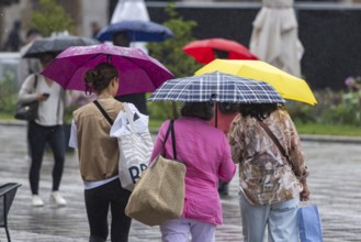 Rainy weather in Stuttgart. People with umbrellas hurry through the rain on Königstraße. Stuttgart,