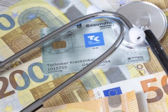 Health insurance contributions Symbolic image: health card, stethoscope and cash