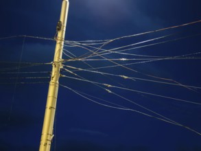 Night shot of many cables and wires for overhead lines on a lamppost in Bratislava, Slovakia
