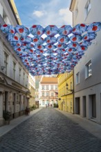 Many umbrellas with poppies over an alley in front of the Nedbalka GalleryBratislava, Slovakia